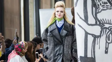 Aktris Elle Fanning memperagakan busana karya Miu Miu pada pagelaran Paris Fashion Week Fall-Winter 2018, Selasa (6/3). Adik dari Dakota Fanning ini memakai coat abu-abu berbahan kulit dengan cutting besar. (Vianney Le Caer/Invision/AP)