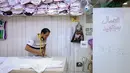 <p>Seorang penjahit memotong kain di tengah tingginya permintaan "dishdasha", pakaian tradisional Kuwait, di toko pakaian adat di Kuwait City pada 23 April 2022. Pakaian tradisional tersebut diburu pembeli, baik tua maupun muda, untuk Idul Fitri yang akan datang. (YASSER AL-ZAYYAT / AFP)</p>