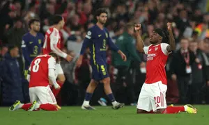Gelandang Arsenal, Noni Madueke, merayakan keberhasilan timnya melangkah ke final Liga Champions 2025/2026 setelah menyingkirkan Atletico Madrid dengan kemenangan agregat 2-1. (Adrian Dennis / AFP)