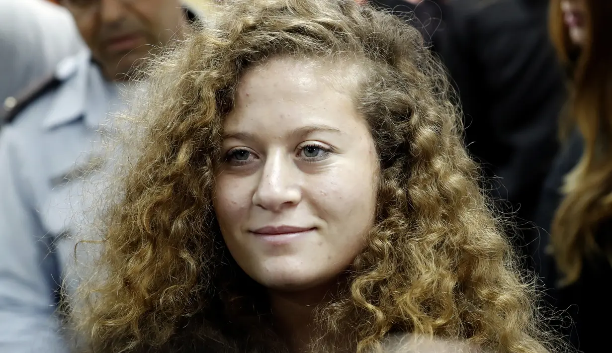 Ekspresi gadis remaja asal Palestina, Ahed Tamimi saat tiba di pengadilan militer Israel di penjara Ofer, Israel (13/2). Ahed Tamimi dipenjara setelah ia memukul dua tentara Israel di daerah Tepi Barat, Israel. (AFP/Thomas Coex)