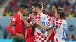 Pemain Kroasia, Josip Sutalo (kanan) terlihat memegang leher dari Azzedine Ounahi dipenghujung babak kedua. Luka Modric yang berada dibelakang Josip Sutalo langsung melerai kejadian tersebut. (AP Photo/Hassan Ammar)