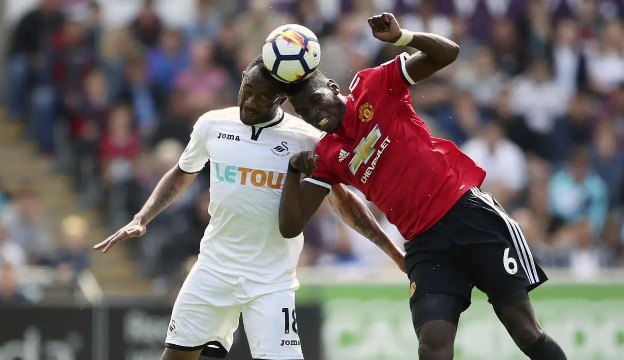 Pemain Swansea City, Jordan Ayew (kiri) berduel dengan pemain Manchester United, Paul Pogba pada lanjutan Premier League di Liberty Stadium, Swansea, (19/8/2017). MU menang 4-0. (Nick Potts/PA via AP)