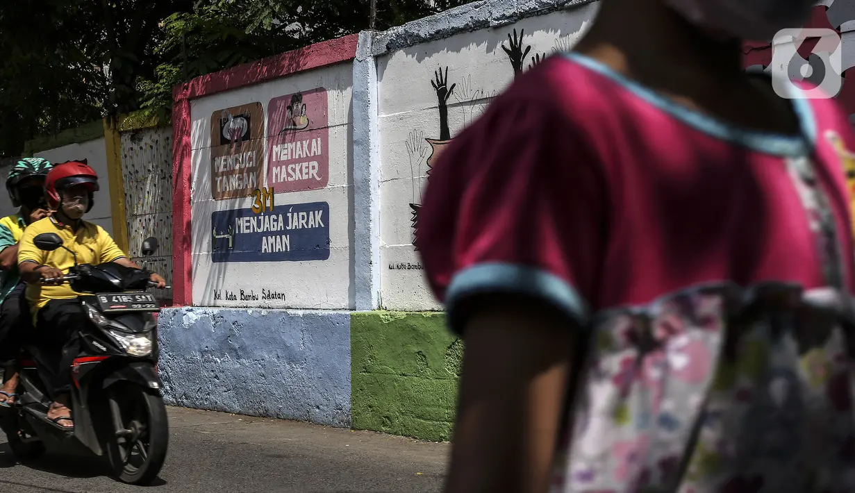 Pengendara melintas dekat mural imbauan untuk mematuhi protokol kesehatan di Jakarta, Selasa (20/7/2021). Kementerian Kesehatan mencatat pasien COVID-19 di Jakarta yang sembuh pada 19 Juli 2021 sebanyak 12.674 atau meningkat dibandingkan 18 Juli 2021 sebanyak 11.857 orang. (Liputan6.com/Johan Tallo)