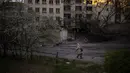 <p>Seorang wanita berjalan melewati lokasi ledakan di Kiev, Ukraina, Jumat (29/4/2022). Rusia menyerang Kiev tak lama setelah pertemuan antara Presiden Ukraina Volodymyr Zelenskyy dan Sekretaris Jenderal PBB António Guterres pada Kamis malam. (AP Photo/Emilio Morenatti)</p>