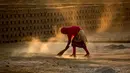 Seorang buruh India menyapu di halaman pabrik pembakaran batu bata di pinggiran Guwahati, India (22/11). Sebagian besar buruh di sini mendapatkan Rupee 120 (kurang dari 2 Dolar) per hari. (AP Photo/Anupam Nath)