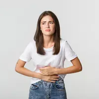 Seorang perempuan merasa kesakitan sambil memegang perutnya (Foto Dok: Freepik/benzoix).