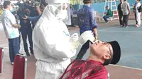 Petugas medis Covid-19 di Riau melakukan tes swab kepada salah satu warga di Pekanbaru. (Liputan6.com/M Syukur)