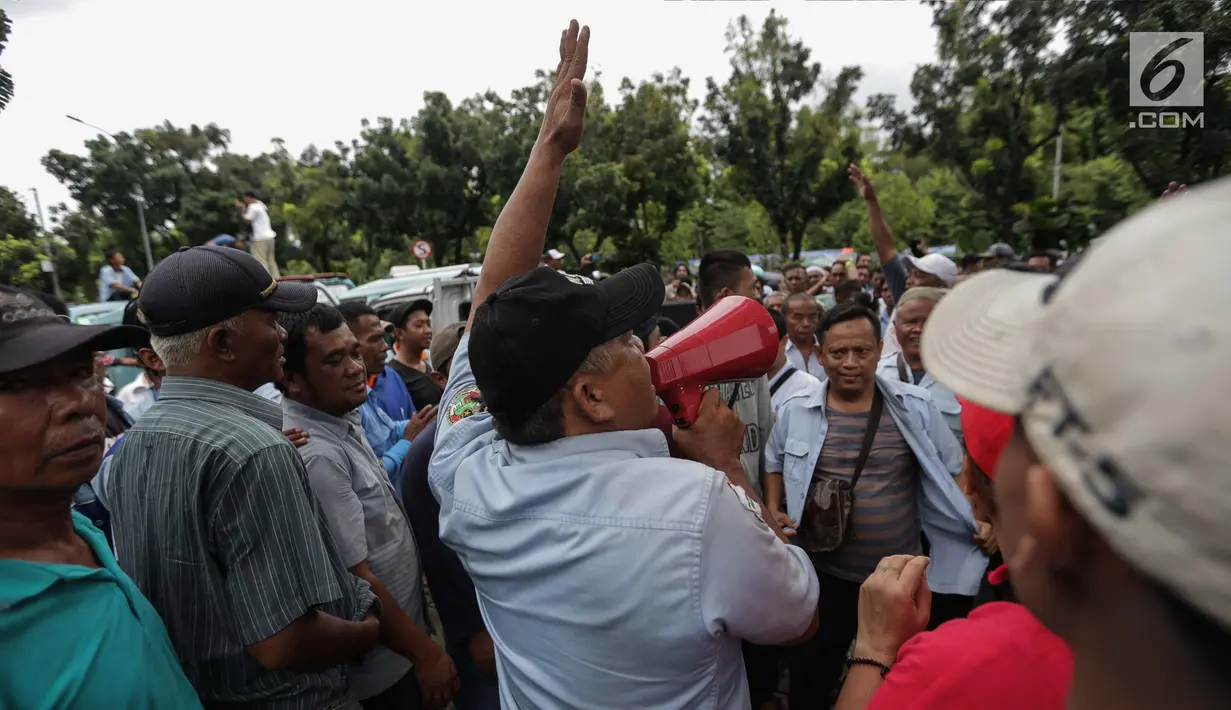 Para pengemudi angkutan melakukan orasi saat menggelar unjuk rasa di depan Balai Kota, Jakarta, Senin (22/1). Dalam aksinya mereka menuntut untuk Jalan Jatibaru Raya dan putaran di depan Blok A Tanah Abang kembali dibuka. (Liputan6.com/Faizal Fanani)