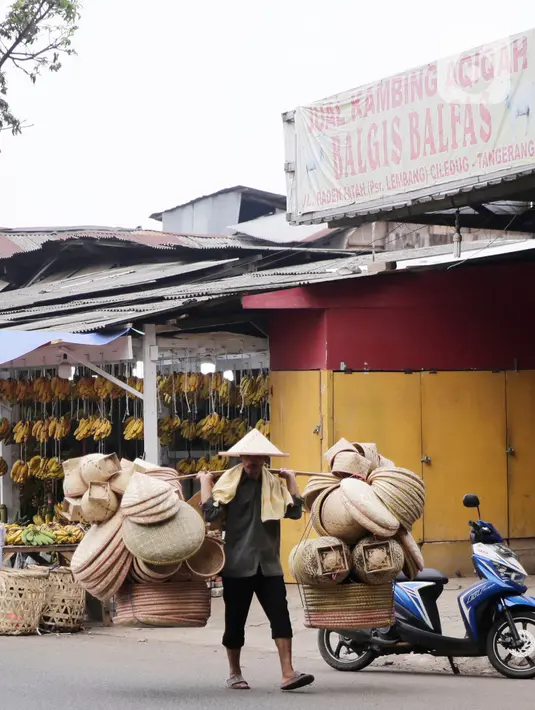Pedagang menggedong daganganya untuk di jaual berkeliling di Tangerang, Banten, Kamis (2/9/2021). Menteri Koperasi dan UKM Teten Masduki menyampaikan realisasi penyaluran BPUM 2021 sudah mencapai Rp14,21 triliun atau 92,35 persen dari total Rp15,36 triliun. (Liputan6.com/Angga Yuniar)