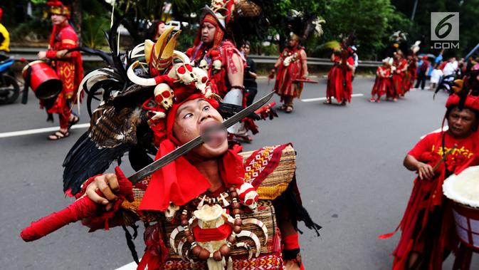 Peserta atraksi Tatung mengiris lidahnya dengan pedang saat arak-arakan perayaan Cap Go Meh di kawasan Petojo, Jakarta, Selasa (19/2). Arak-arakan ini melewati kawasan Petojo hingga Cideng. (Liputan6.com/Angga Yuniar)