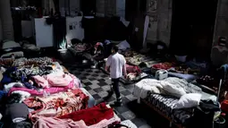 Seorang perawat berjalan di Gereja Saint-Jean-Baptiste-au-Beguinage yang diduduki oleh para migran tidak berdokumen di Brussel, Beliga, Rabu (2/6/2021). Para migran menyerukan lebih banyak inisiatif untuk memungkinkan mereka bekerja.
(Kenzo TRIBOUILLARD/AFP)