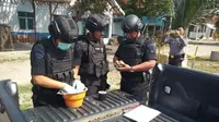 Tim Jibom dan Gegana Polda Jateng mengecek benda diduga granat yang ditemukan seorang petani di Puring, Kebumen. (Liputan6.com/Dok. Polres Kebumen untuk Muhamad Ridlo)
