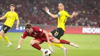 Striker Timnas Indonesia, Luke Vickery, terjatuh setelah menghindari bek Malaysia, Dion Cools, pada Grup B FIFA ASEAN Cup 2026 di Stadion Utama Gelora Bung Karno, Jakarta, Senin (28/9/2026). (Bola.com/Budy Santoso)