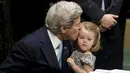 Menteri Luar Negeri AS John Kerry mencium cucunya Isabelle Dobbs-Higginson saat menandatangani surat Perjanjian Paris tentang perubahan iklim di Markas Besar PBB, Manhattan, New York, AS (22/4). (REUTERS / Carlo Allegri)