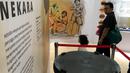 Pengunjung melihat bejana dandang perunggu pada pameran Asal Usul Orang Indonesia (ASOI) di Museum Nasional Jakarta, Minggu (3/11/2019). ASOI merupakan pameran yang menampilkan fase perkembangan manusia purba mulai dari Homo Erectus Tipik hingga Homo Sapiens. (Liputan6.com/Fery Pradolo)