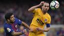 Bek Atletico Madrid, Diego Godin, duel udara dengan striker Barcelona, Luis Suarez, pada laga La Liga Spanyol di Stadion Camp Nou, Barcelona, Minggu (4/3/2018). Barcelona menang 1-0 atas Atletico. (AFP/Lluis Gene)