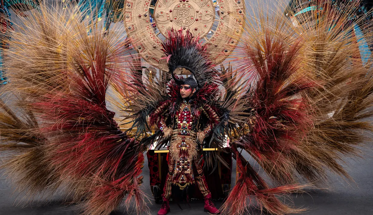 Seorang peserta mengenakan kostum dalam Jember Fashion Carnaval (JFC) di Jember, Provinsi Jawa Timur pada Minggu (4/8/2019). Kegiatan ini mengangkat tema 'tribal grandeur', dengan menghadirkan keagungan 8 suku di dunia. (Photo by JUNI KRISWANTO / AFP)