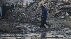 Warga Palestina berjalan di tengah bangunan yang hancur akibat serangan udara dan darat Israel di Kota Gaza, Selasa 6 Januari 2026. Komite Internasional Palang Merah (ICRC) terus berupaya menyalurkan bantuan ke Gaza. (AP Photo/Jehad Alshrafi)