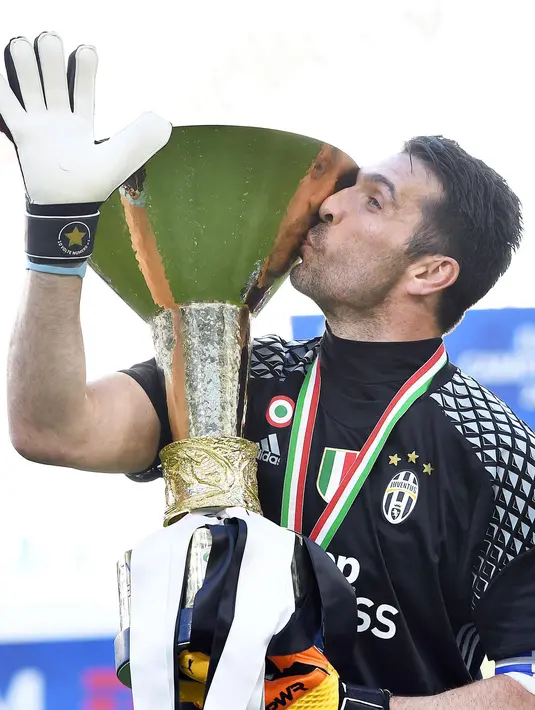 Kiper Juventus, Gianluigi Buffon mencium trofi Liga Italia di Juventus Stadium, Turin, (21/5). Juventus menjadi tim pertama dalam sejarah yang bisa meraih enam scudetto secara beruntun. (Alessandro Di Marco/ANSA via AP)