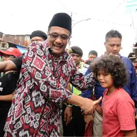 Cawagub petahana, Djarot Syaiful Hidayat menyalami seorang anak saat sosialisasi di kawasan Pademangan VIII, Jakarta, Kamis (23/3). Selain sosialisasi dengan warga, Djarot juga menyerap keluhan warga sekitar. (Liputan6.com/Helmi Fithriansyah)  