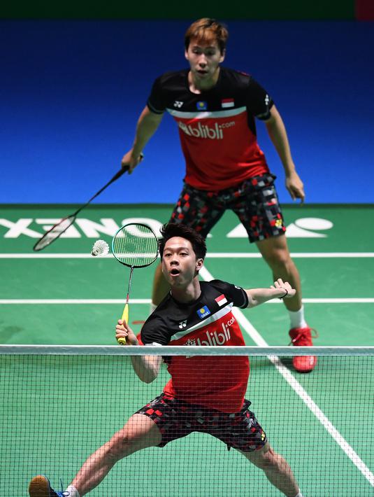 Ganda putra Kevin Sanjaya/Marcus Fernaldi Gideon berusaha mengembalikan kok saat bertanding melawan Hendra Setiawan / Mohammad Ahsan pada babak fina Jepang Terbuka 2019 di Tokyo (28/7/2019). Hasil final Japan Open 2019 membuat Kevin / Marcus mempertahankan gelar juara. (AFP Photo/Charly Triballeau)
