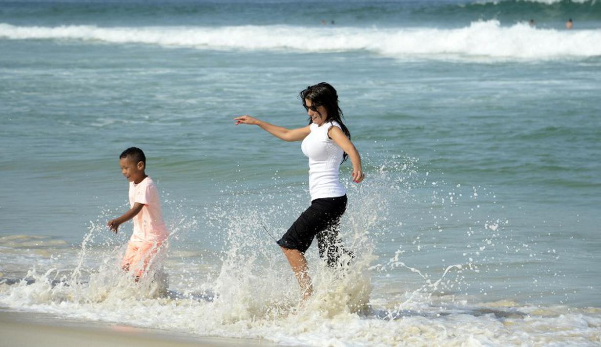  Ludivine tampak bercanda dengan anaknya di pantai Rio de Janeiro, Brasil (26/6/2014) (AFP PHOTO/FRANCK FIFE)