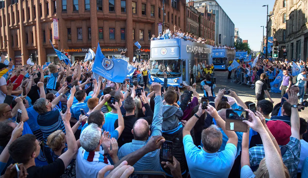 Ribuan suporter memadati jalan saat Manchester City melakukan parade merayakan keberhasilan menjadi juara Liga Primer Inggris di Manchester, Senin (14/5). Manchester City menjuarai Liga Inggris untuk ke-18 kalinya  (Anthony Devlin/PA via AP)