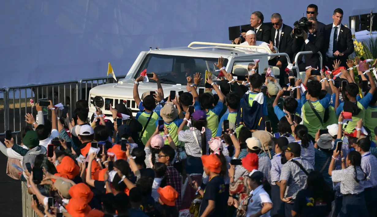 Menaiki mobil Maung buatan PT Pindad, Paus Fransiskus menyapa umat Katolik yang memadati Stadion Utama Gelora Bung Karno, Jakarta. (BAY ISMOYO/AFP)