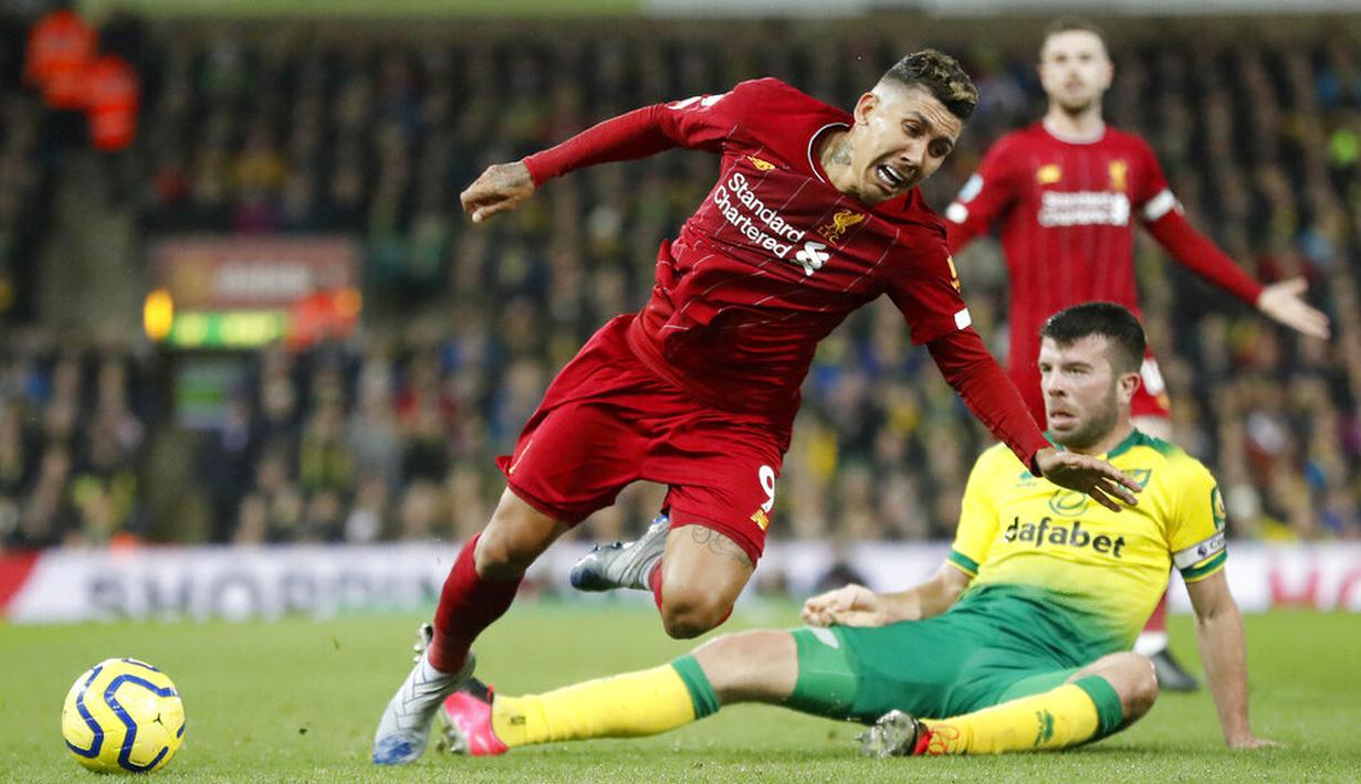 Penyerang Liverpool, Roberto Firmino, terjatuh saat berebut bola dengan pemain Norwich City, Grant Hanley, pada laga Premier League di Stadion Carrow Road Minggu (16/2/2020). Liverpool menang 1-0 atas Norwich City. (AP/Frank Augstein)