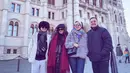 Berada di Hungary, Liza mengenakan jaket puffer abu-abu dipadukan celana ketat hitam. Putrinya mengenakan coat coklat dipadukan syal merah dan celana panjang hitamnya. [@lizanataliaofficial]