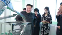 Gambar tak bertanggal yang dirilis kantor berita KCNA pada 29 Oktober 2017 memperlihatkan pemimpin Korea Utara, Kim Jong-Un ditemani istrinya, Ri Sol-Ju, tersenyum ketika memeriksa pabrik kosmetik di Pyongyang. (AFP PHOTO / KCNA VIA KNS / STR)