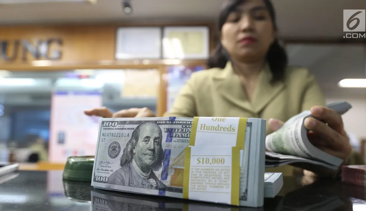 Pekerja menghitung mata uang Dolar AS di jasa penukaran uang asing di Jakarta, Rabu (19/6/2019). Nilai tukar rupiah terhadap Dolar AS sore ini Rabu (19/6) ditutup menguat sebesar Rp 14.269 per dolar AS atau menguat 56,0 poin (0,39 persen) dari penutupan sebelumnya. (Liputan6.com/Angga Yuniar)