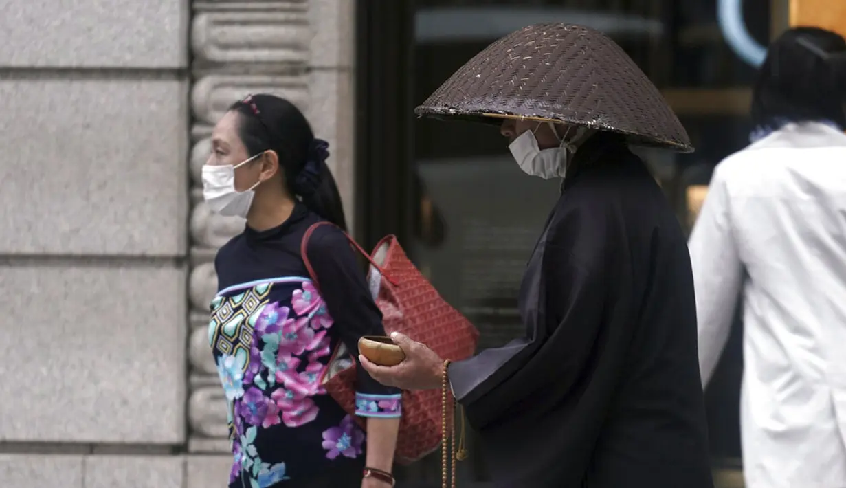 Seorang biksu Buddha yang mengenakan masker untuk membantu mengekang penyebaran virus corona COVID-19 berdoa di distrik perbelanjaan Ginza, Tokyo, Jepang, Rabu (28/10/2020). Tokyo mengonfirmasi lebih dari 170 kasus virus corona COVID-19 baru pada 28 Oktober 2020. (AP Photo/Eugene Hoshiko)