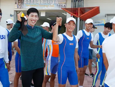 Keakraban atlet Korea Selatan dan Korea Utara saat menghadiri sesi latihan bersama jelang Asian Games 2018 di Tangeum Lake International Rowing Center, Chungju, Korea Selatan, Selasa (31/7). (Jeon Heon-Kyun/Pool/AFP)