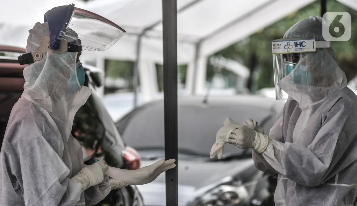 Tenaga kesehatan bersiap mengambil sampel lendir untuk tes usap PCR drive thru di halaman Rumah Sakit Pertamina Jakarta (RSPJ), Rabu (6/1/2021). Kegiatan tes usap drive thru di RSPJ digelar setiap hari mulai pukul 08.00 WIB- 16.00 WIB dengan tarif Rp900 ribu per orang. (merdeka.com/Iqbal Nugroho)