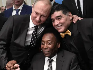 Legenda sepak bola, Diego Maradona dan Pele, foto bersama dengan Presiden Rusia, Vladimir Putin, saat menghadiri Drawing Piala Dunia 2018 di Kremlin Palace, Jumat (1/12/2017). Acara tersebut dihadiri legenda sepak bola dunia. (AFP/Alexey Nikolsky)