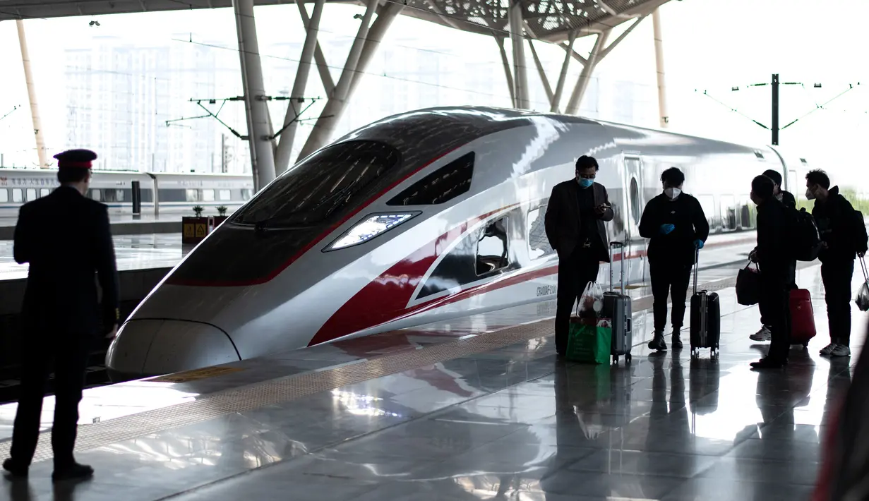 Penumpang (kanan) antre untuk menaiki kereta api menuju Beijing di stasiun kereta Wuhan, provinsi Hubei, Rabu (15/4/2020). Usai status lockdown dicabut pada 8 April, orang-orang yang sebelumnya berada di Wuhan perlahan mulai meninggalkan kota, salah satu tujuannya adalah Beijing.  (NOEL CELIS/AFP)