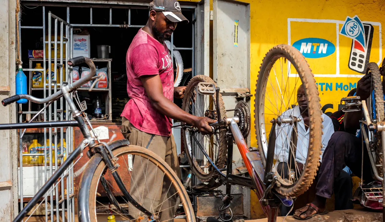 Seorang pria memperbaiki sepeda di Kampala, ibu kota Uganda (30/6/2020). Warga Uganda kini beralih menggunakan sepeda sebagai sarana transportasi yang mendukung di tengah pandemi COVID-19. (Xinhua/Hajarah Nalwadda)