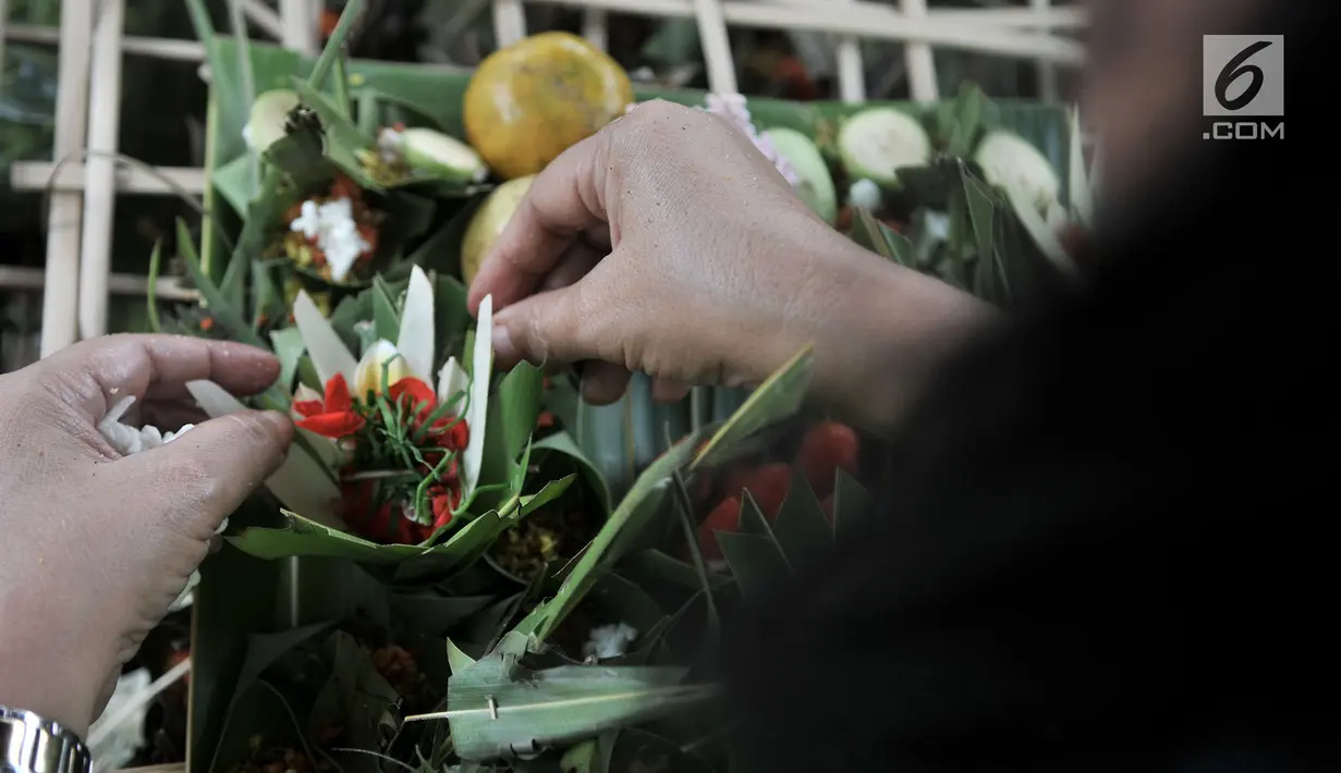 Umat Hindu bersama-sama membuat sajen (Ngayah) di Pura Aditya Jaya, Jakarta, Senin (4/3). Ngayah merupakan tradisi yang dilakukan gotong-royong oleh kaum perempuan Hindu dalam membuat sajen untuk persiapan sembahyang  Nyepi. (merdeka.com/Iqbal S. Nugroho)