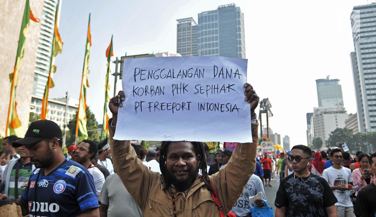 Masyarakat Papua yang merupakan mantan karyawan PT Freeport Indonesia saat melakukan penggalangan dana di tengah berlangsungnya Hari Bebas Kendaraan Bermotor atau Car Free Day di kawasan Bundaran HI, Jakarta, Minggu (5/8). (Merdeka.com/Iqbal S. Nugroho)