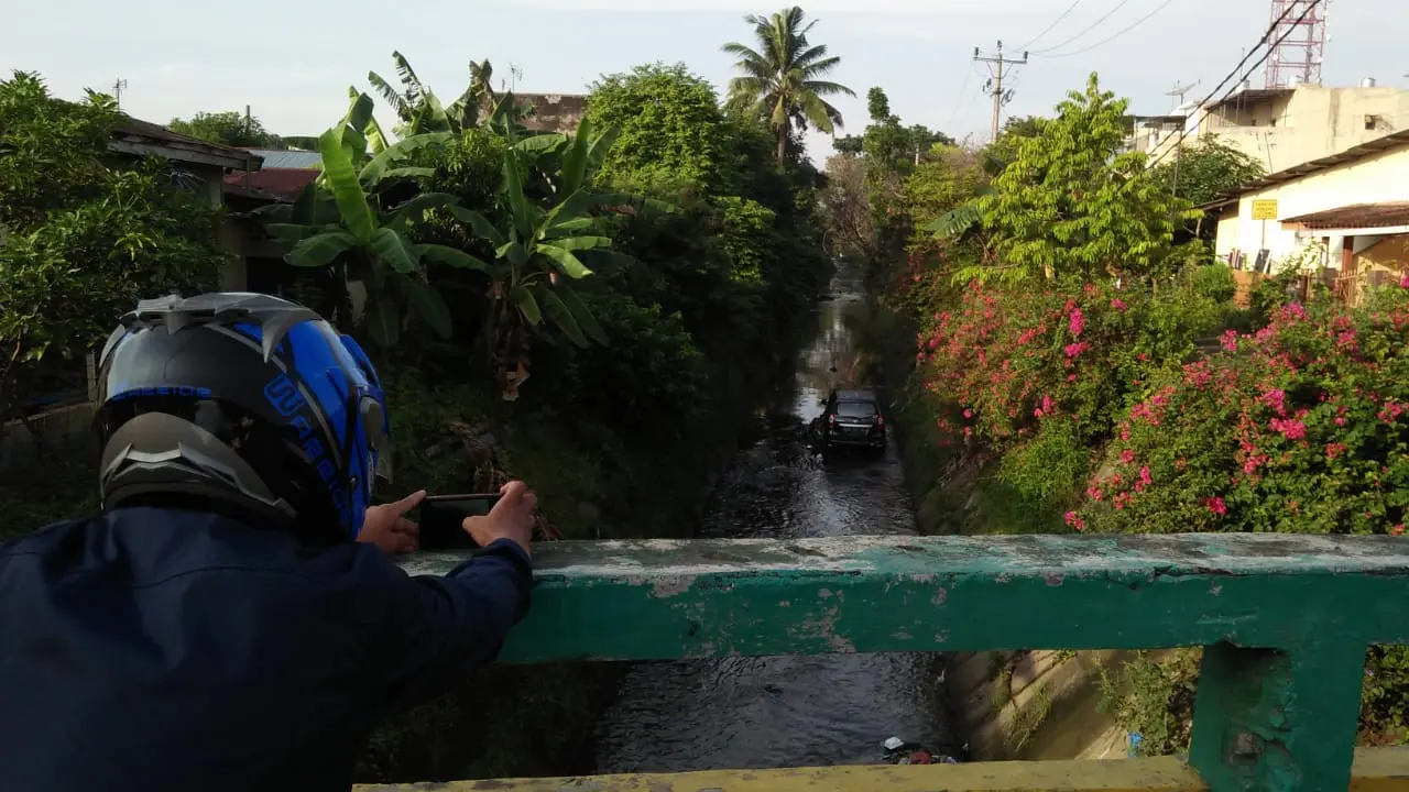 Mobil Parkir di Tengah Parit Curi Perhatian Warga Medan