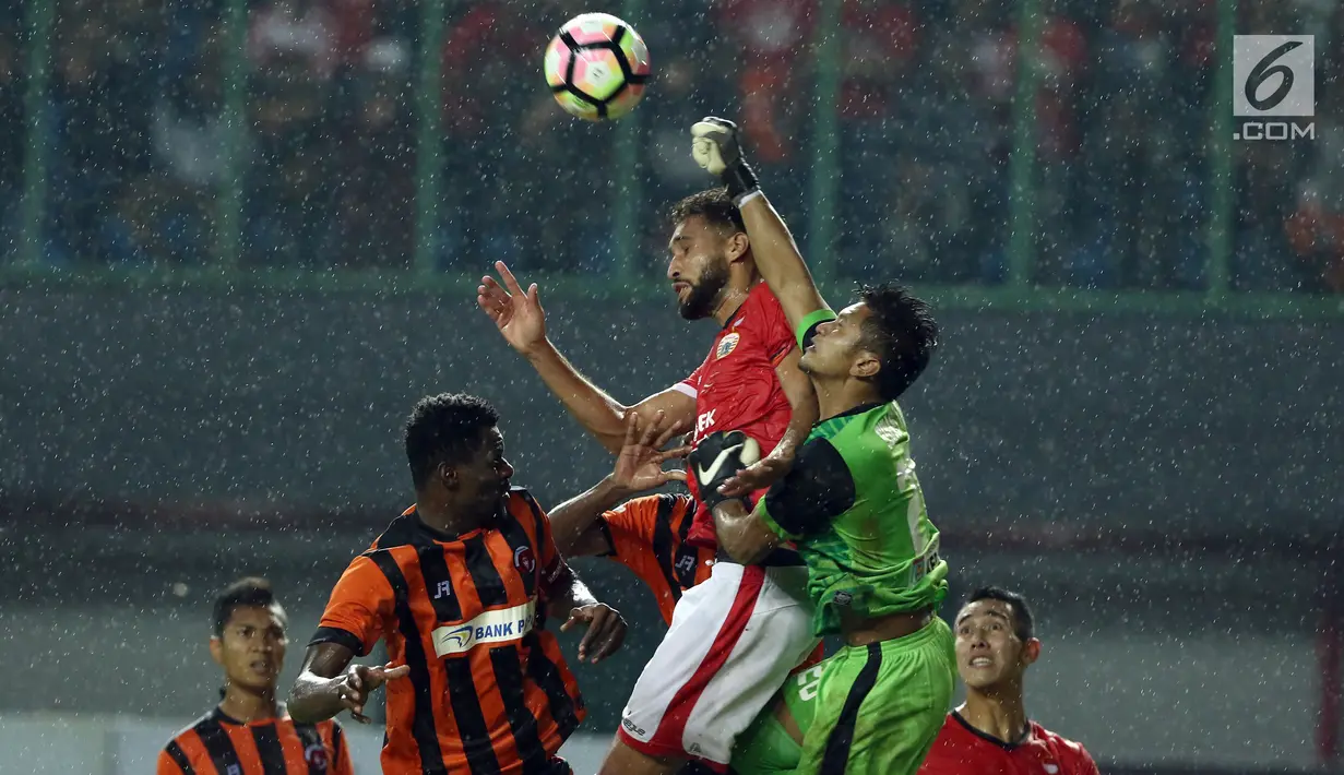 Bek Persija, Willian Pachecho berebut bola dengan penjaga gawang Perserui Sukasto Efendi dilanjutan Liga 1 Indonesia di Stadion Patriot Candrabhaga, Bekasi, Selasa (13/6). Persija menang telak 3-0 atas perserui. (Liputan6.com/Helmi Fithriansyah)