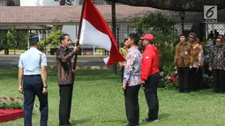 Presiden Joko Widodo memberikan bendera merah putih kepada Ketum INAPGOC 2018 Raja Sapta Oktohari saat pelepasan kontingen atlet dan official Indonesia Asian Para Games 2018 di Halaman Istana Negara, Jakarta, Selasa (2/10). (Liputan6.com/Angga Yuniar)