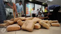 Petugas Dir IV Narkoba Mabes Polri membongkar puluhan pak ganja saat rilis di Jakarta, Selasa (24/5/2016). Petugas menahan enam orang tersangka dengan barang bukti narkoba jenis ganja seberat satu ton. (Liputan6.com/Helmi Fithriansyah)
