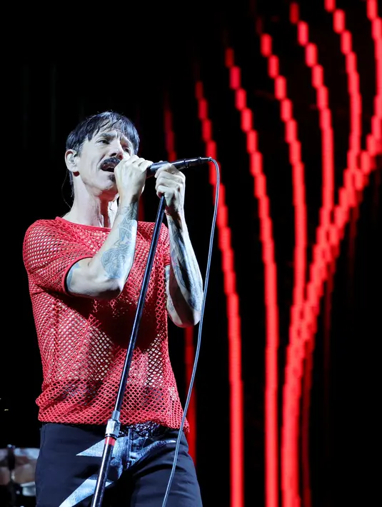 Vokalis Red Hot Chili Peppers, Anthony Kiedis menyanyikan sebuah lagi di atas panggung di Allegiant Stadium di Las Vegas, Nevada (6/8/2022). Red Hot Chilis Peppers membawakan lagu seperti Give It Away, Californication. (Ethan Miller/Getty Images/AFP)