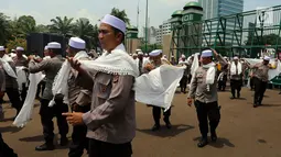 Personel Brimob yang tergabung dalam Pasukan Dzikir Asmaul Husna mengenakan sorban bersiap menjalankan salat di depan Gedung MPR/DPR, Senayan, Jakarta, Selasa (24/10). (Liputan6.com/JohanTallo)