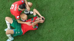 Bek Maroko, Achraf Hakimi (kanan) dihibur oleh rekan setimnya Romain Ghanem Saiss setelah pertandingan semifinal Piala Dunia 2022 di Stadion Al-Bayt di Al Khor, Doha, Kamis (15/12/2022). Maroko gagal melaju ke final Piala Dunia 2022 Qatar setelah kalah dari Prancis dengan skor 2-0. (AFP/Giuseppe Cacace)