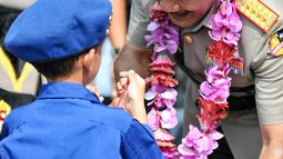 Kapolri Jenderal Polisi Badrodin memberikan hadiah kepada seorang anak kecil dalam peringatan HUT ke65 Pol Airud di Markas Korps Direktorat Polisi Udara Baharkam Polri, Pondok Cabe, Pamulang, Tangerang Selatan, Senin (1/12). (Liputan6.com/Yoppy Renato)