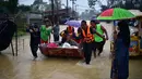 Warga diangkut melalui banjir di distrik Ran-ngea di provinsi Narathiwat, Thailand selatan (26/2/2022).  Lebih dari 7.200 rumah tangga di 195 desa telah terkena dampak, dengan 6.891 rumah rusak, karena Sungai Sungai Kolok yang diguyur hujan terus meluap. (AFP/Madaree Tohlala)