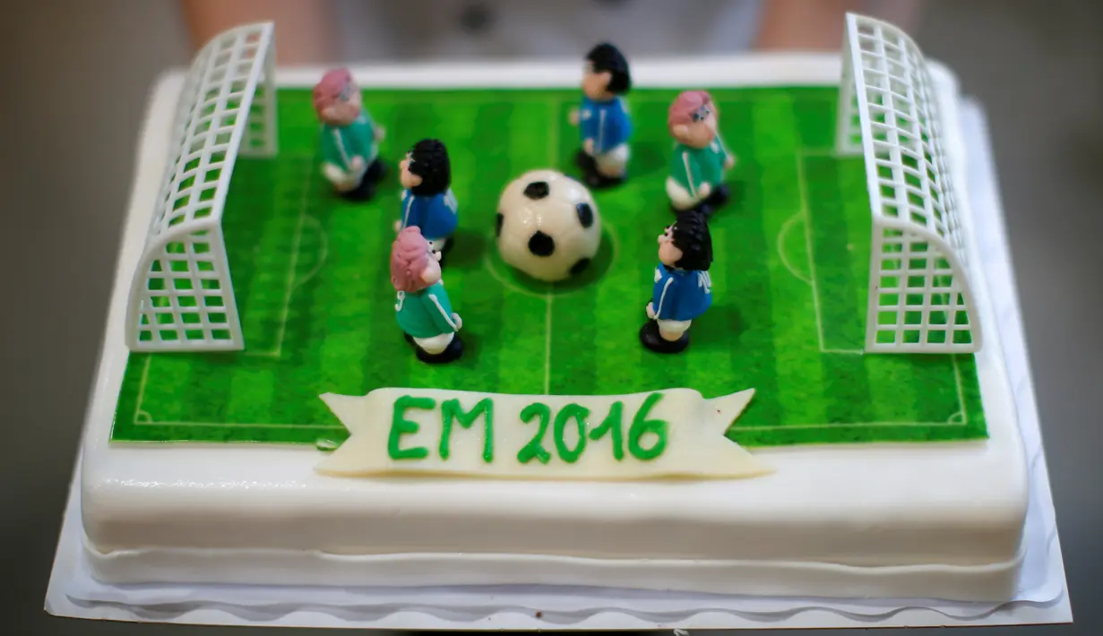 Seseorang menunjukkan salah satu kue bertema Euro 2016 yang dibuat di sebuah tempat pembuatan kue di Munich, Jerman, Senin (20/6). Beraneka kue bertema Euro 2016 mewarnai perhelatan sepakbola Eropa. (REUTERS/Michaela Rehle)